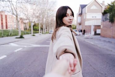Porträt einer jungen Frau, die auf der Straße die Hand hält - EBBF00171