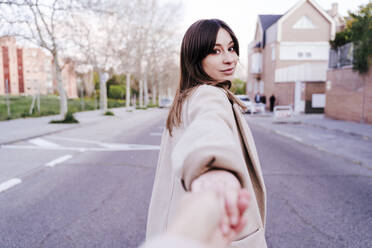 Portrait of young woman holding hand on the street - EBBF00171