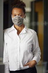 Portrait of businesswoman wearing homemade protective mask - RBF07687