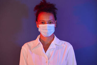 Portrait of businesswoman wearing light blue protective mask - RBF07690