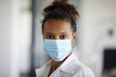 Portrait of businesswoman wearing light blue protective mask - RBF07693