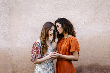 Porträt von zwei jungen Frauen, die sich an den Händen halten - TCEF00662