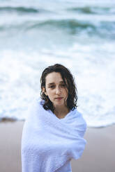 Junge Frau, eingewickelt in ein weißes Handtuch, am Praia da Ursa, Lisboa, Portugal - FVSF00343
