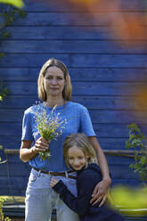 Porträt von Mutter und Tochter mit Blumen im Garten - MCF00825