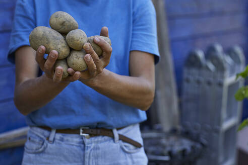 Nahaufnahme einer Frau mit Kartoffeln im Gartenhaus - MCF00902