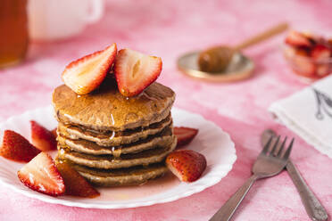 Teller mit Bananenpfannkuchen mit Honig und Erdbeeren - FLMF00228