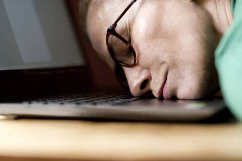 Tred reife Frau schläft während der Ausgangssperre zu Hause am Laptop, lizenzfreies Stockfoto