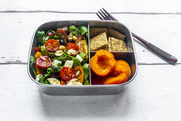 Lunchbox mit Rucolasalat mit bunten Tomaten, Mozzarella und Nüssen, Knäckebrot und Aprikosen, Holzgabel - SARF04589