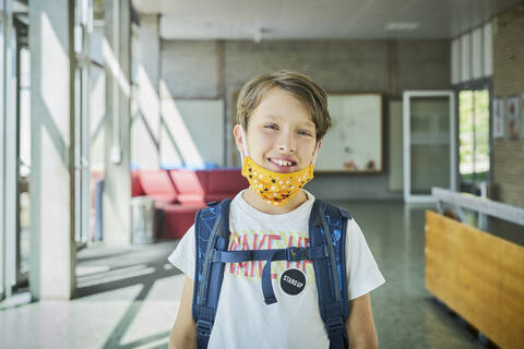 Portrait of smiling boy wearing mask in school stock photo