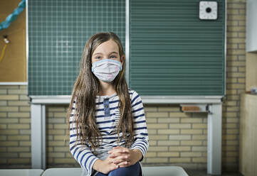 Porträt eines Mädchens mit Maske im Klassenzimmer - DIKF00512