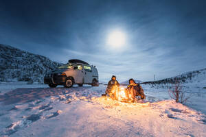 Camper am Lagerfeuer in Winterlandschaft in Polarnacht, Kilpisjaervi, Enontekioe, Finnland - WVF01531