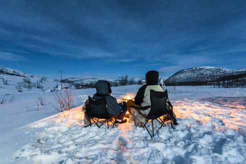 Camper am Lagerfeuer in Winterlandschaft in Polarnacht, Kilpisjaervi, Enontekioe, Finnland - WVF01532