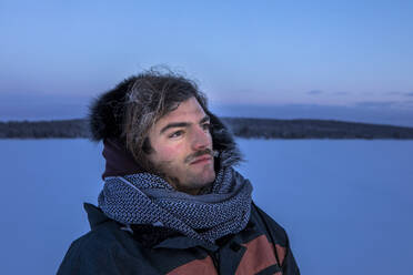 Porträt eines Mannes in Winterlandschaft mit gefrorenem Schnurrbart, Ounasjaervi, Enontekioe, Finnland - WVF01548