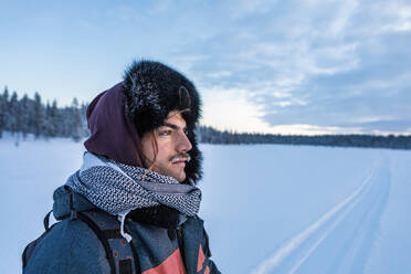 Porträt eines Mannes in Winterlandschaft mit gefrorenem Schnurrbart, Ounasjaervi, Enontekioe, Finnland - WVF01552