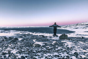 Mann in winterlicher Küstenlandschaft am Lakse Fjord, Lebesby, Norwegen - WVF01638