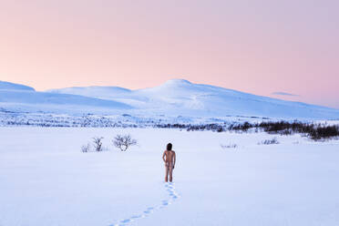 Nude man standing in winter landscape, Lebesby, Norway - WVF01646