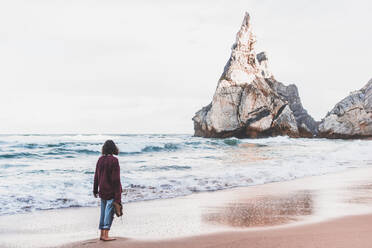 Woman standing on shore at Ursa Beach, Lisboa Region, Portugal - FVSF00362
