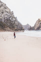 Junge Frau beim Spaziergang am Ursa-Strand, Region Lisboa, Portugal - FVSF00369