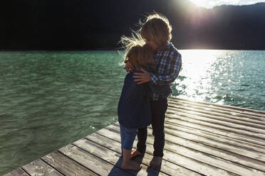 Bruder küsst Schwester auf der Uferpromenade am Achensee, Bundesland Tirol, Österreich - JLOF00400