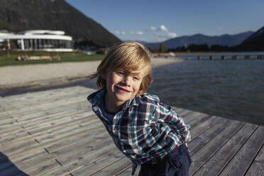 Happy boy standing on boardwalk at Achensee, Tyrol State, Austria - JLOF00408