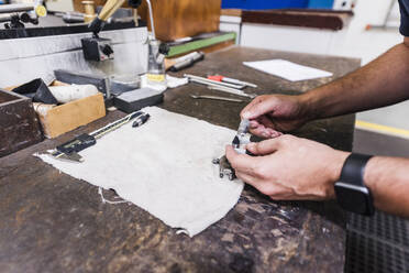 Close-up of man working at workbench in a factory - DIGF11367