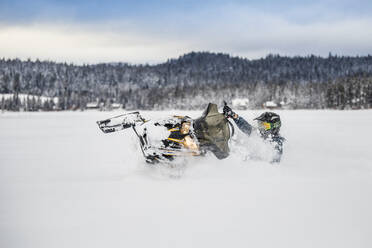 Erfahrener Fahrer steuert Schneemobil sicher im Tiefschnee. - CAVF82053