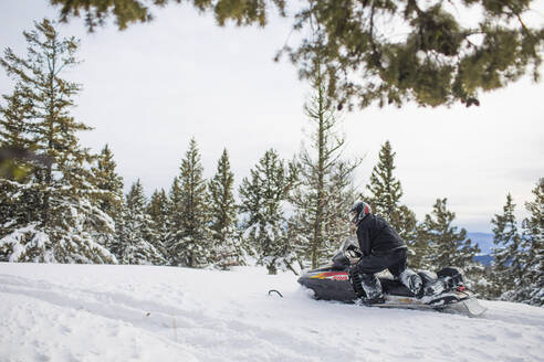 Rentner genießt in seiner Freizeit das Schneemobilfahren - CAVF82057