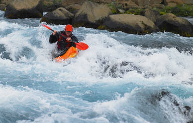 Man going on his white water kayak rapids in an Icelandic river - CAVF82142