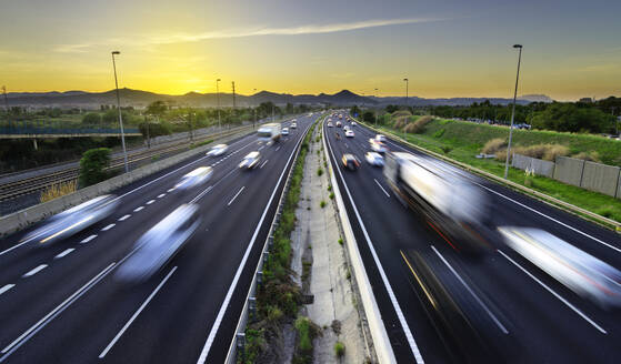 Busy highway at sunset, vehicles coming and going, city stress - - CAVF82161