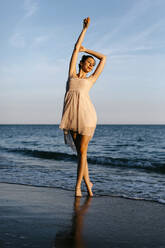 Zarte Ballerina tanzt bei Sonnenuntergang am Strand - TCEF00672