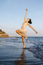 Delicate ballerina dancing on the beach at sunset - TCEF00673