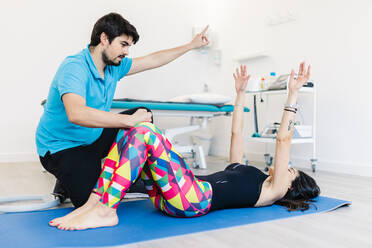 Visually impaired physical therapist instructing woman in exercises at clinic - MRRF00052