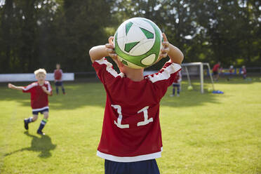 Fußballjunge wirft Ball auf Feld - AUF00510