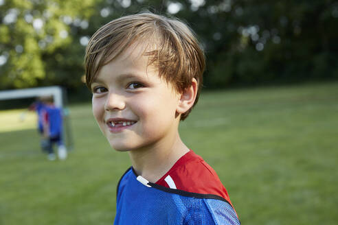 Close-up portrait of happy soccer boy on field - AUF00512