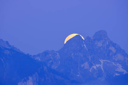 Deutschland, Bayern, Mond versteckt sich hinter den Gipfeln der Tannheimer Berge in der blauen Morgendämmerung - SIEF09861