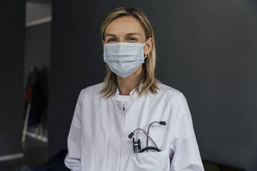 Portrait of doctor wearing protective mask against grey background - MFF05621