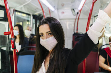 Porträt einer jungen Frau mit Schutzmaske in einem öffentlichen Bus, Spanien - DGOF01037