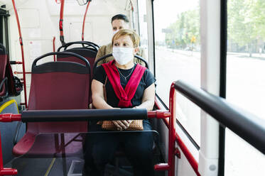 Porträt einer reifen Frau mit Schutzmaske in einem öffentlichen Bus, Spanien - DGOF01039