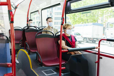Fahrgäste mit Schutzmasken in einem öffentlichen Bus, Spanien - DGOF01040