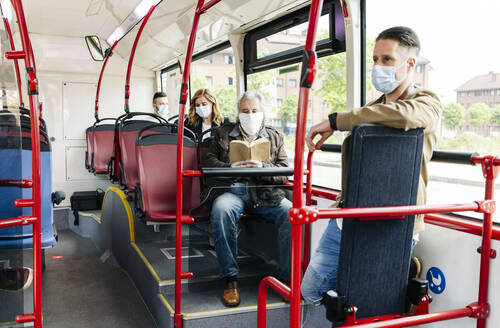 Fahrgäste mit Schutzmasken in einem öffentlichen Bus, Spanien - DGOF01044