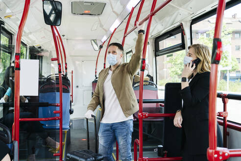 Fahrgäste mit Schutzmasken in einem öffentlichen Bus, Spanien - DGOF01060