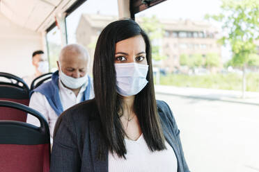 Porträt einer Frau mit Schutzmaske in einem öffentlichen Bus, Spanien - DGOF01071