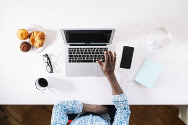 Mann mit Laptop bei der Arbeit am Schreibtisch im Heimbüro - JCMF00768