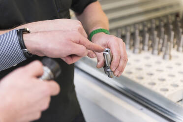 Close-up of two men with a product in a factory - DIGF11430