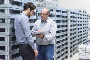 Two businessmen with tablet having a discussion in a factory - DIGF11456