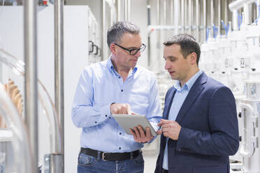 Two businessmen with tablet having a discussion in a factory - DIGF11505