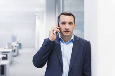 Businessman talking on the phone in office - DIGF11520