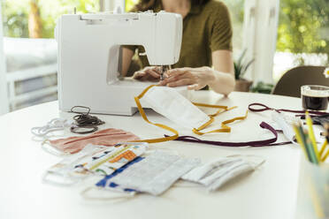 Close-up of woman sewing face masks at home - MFF05657