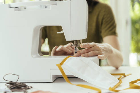 Close-up of woman sewing face masks at home - MFF05658