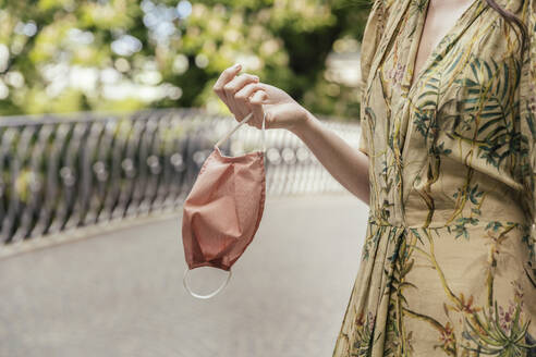 Close-up of woman holding face mask - MFF05759